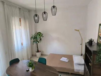 a living room with a table and a room with a bed at The italian House in Rome a pochi passi dalla metro A in Rome