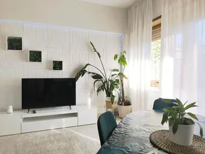a living room with a tv and a table with plants at The italian House in Rome a pochi passi dalla metro A in Rome