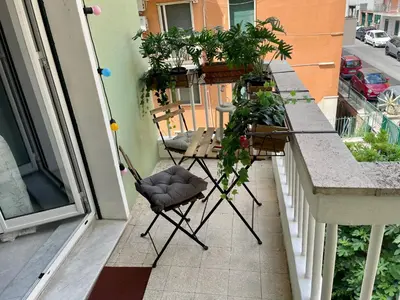 a balcony with two chairs and potted plants on it at Aurelia's Hideaway, Near Vatican in Rome