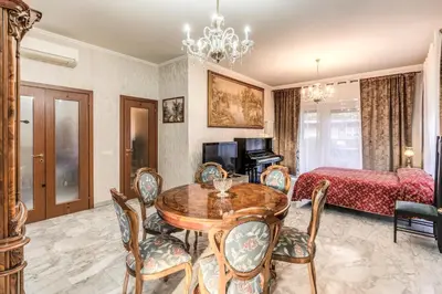 a living room with a dining room table and a bedroom at Vacanze romane in Rome
