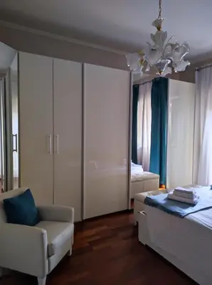 a bedroom with a bed and a chair and a chandelier at Vacanze romane in Rome