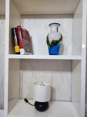 a shelf with a vase and a candle and books at Vacanze romane in Rome