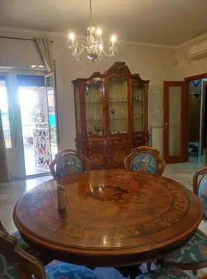 a dining room table with chairs and a chandelier at Vacanze romane in Rome