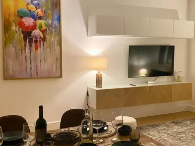 a living room with a table with wine bottles and a tv at Maison de charme Domus Clodio XIV in Rome