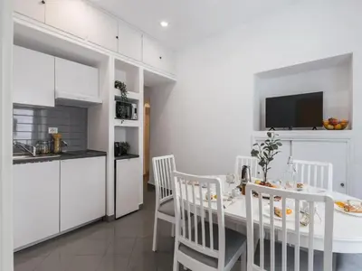 a kitchen and dining room with a white table and chairs at The Best Rent - Two-bedroom apartment in Colosseum area in Rome
