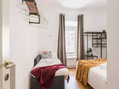 a bedroom with two beds and a window at The Best Rent - Spacious three-bedroom apartment near the Colosseum in Rome