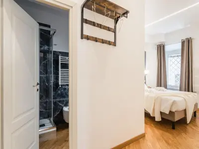 a bedroom with a bed and a door leading to a bathroom at The Best Rent - Spacious three-bedroom apartment near the Colosseum in Rome