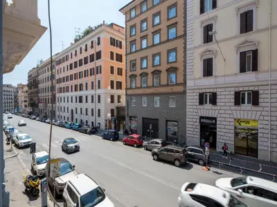 a busy city street with cars parked on the street at The Best Rent - Spacious three-bedroom apartment near the Colosseum in Rome