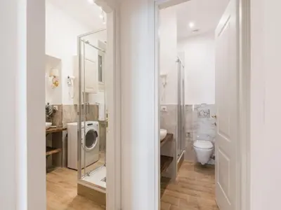 a bathroom with a toilet and a washing machine at The Best Rent - Spacious three-bedroom apartment near the Colosseum in Rome