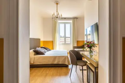 a bedroom with a bed and a desk with a chair at La Maison Royale in Rome