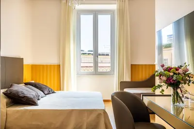 a bedroom with a bed and a table and a window at La Maison Royale in Rome