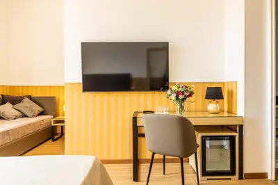 a room with a table and a television on a wall at La Maison Royale in Rome