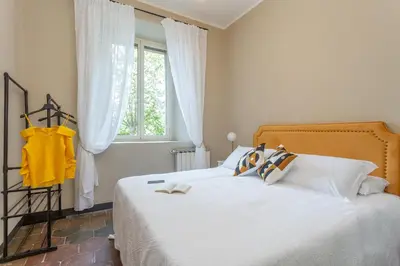 a bedroom with a bed with white sheets and a window at Daplace - Beatrice Apartment in Rome