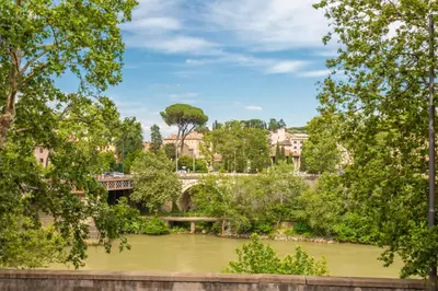a view of a bridge over a river with trees at Daplace - Beatrice Apartment in Rome