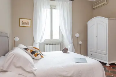 a bedroom with a white bed with a laptop on it at Daplace - Beatrice Apartment in Rome
