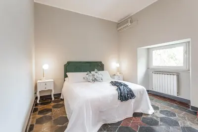 a bedroom with a bed and two tables and a window at Daplace - Beatrice Apartment in Rome