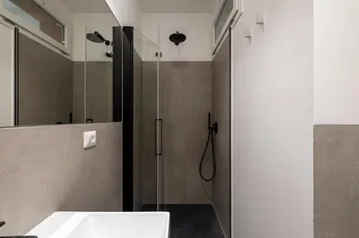 a bathroom with a shower with a sink and a glass door at Suite close to Vatican City - Ingresso Spa in Rome
