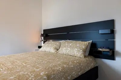 a bedroom with a large bed with a blue headboard at Suite close to Vatican City - Ingresso Spa in Rome
