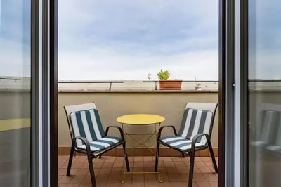 two chairs and a table on a balcony at Flat on Roman Rooftop in Rome