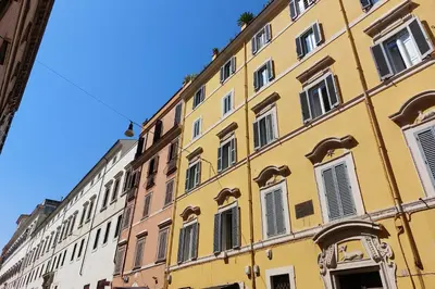 a yellow building with white windows on a street at Youroom Quattro Fontane - Rooms in Rome