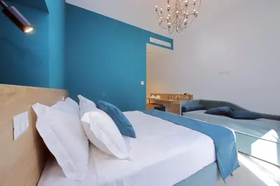 a bedroom with blue walls and a bed with pillows at Youroom Quattro Fontane - Rooms in Rome