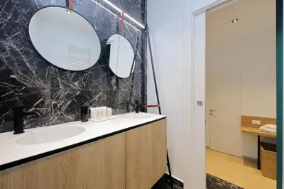 a bathroom with a sink and a mirror at Youroom Quattro Fontane - Rooms in Rome