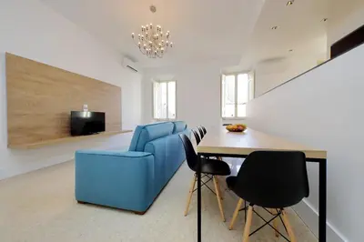 a living room with a blue couch and a table at Youroom Quattro Fontane - Rooms in Rome
