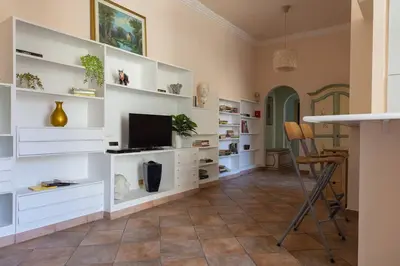 a living room with white shelves and a television at La Dolce Vita - IRIDE's Nest in Rome