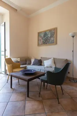 a living room with a couch and a table and chairs at La Dolce Vita - IRIDE's Nest in Rome