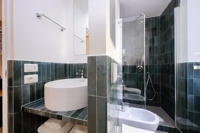 a bathroom with a sink and a toilet and a mirror at YCH-Montebello - Rooms in Rome