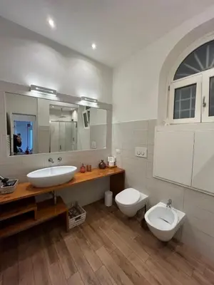 a bathroom with a sink and a toilet and a mirror at La Dolce Vita - Luxury Colosseum Boutique Apartment in Rome