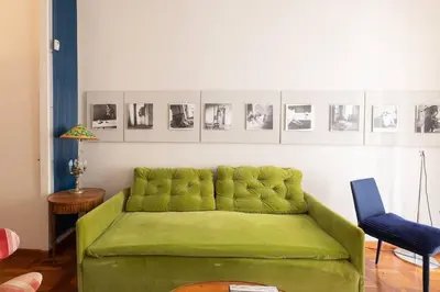 a green couch in a living room with pictures on the wall at La Dolce Vita - Old Testaccio Authentic District in Rome