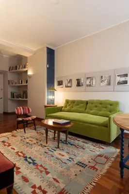 a living room with a green couch and a table at La Dolce Vita - Old Testaccio Authentic District in Rome
