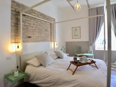 a bedroom with a large white bed with a table at Roma Testaccio - Volta 45 apartment in Rome
