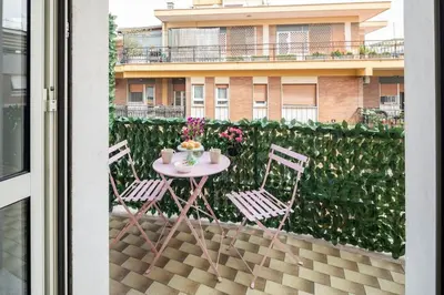 a table and chairs on a balcony with a building at tibershome home la casa sul tevere in Rome