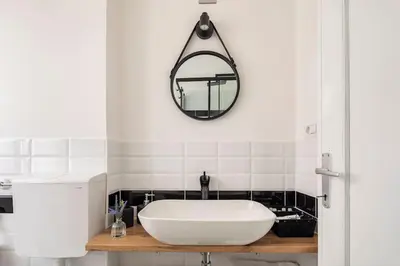 a bathroom with a white sink and a mirror at tibershome home la casa sul tevere in Rome