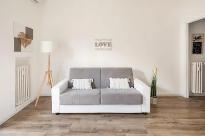 a white couch with two pillows in a living room at tibershome home la casa sul tevere in Rome