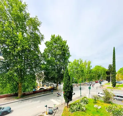 a city street with trees and cars on the road at Giardino degli Aranci Lulus Home in Rome