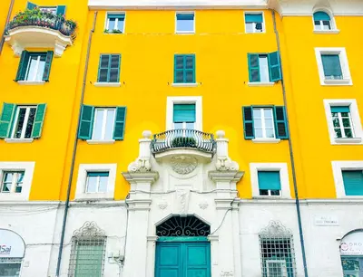 a yellow building with a green door in front of it at Giardino degli Aranci Lulus Home in Rome