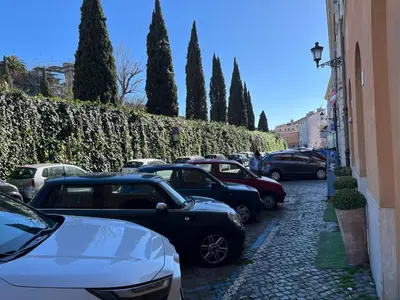 a row of cars parked on a street with trees at Shabby Roman Studio- ai fori Imperiali in Rome