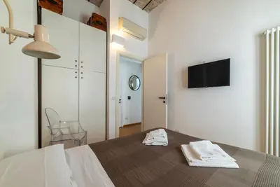 a bedroom with a bed with a tv on the wall at GuestHost - Cancelleria Rooftop Garden in Rome