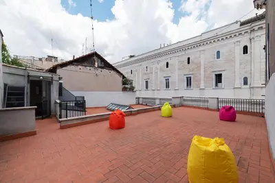 three colorful bags sitting on a brick patio in front of a building at GuestHost - Cancelleria Rooftop Garden in Rome