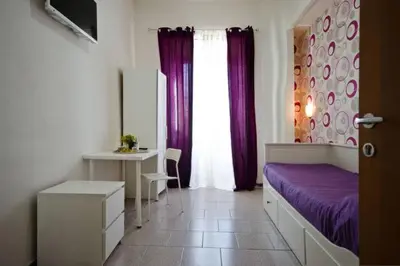 a bedroom with a bed and a desk and a window at Hostel Castello Maggiore in Rome