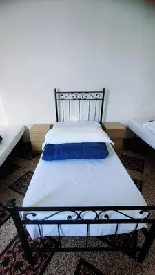 a bedroom with a bed with blue pillows on it at Hostel Castello Maggiore in Rome