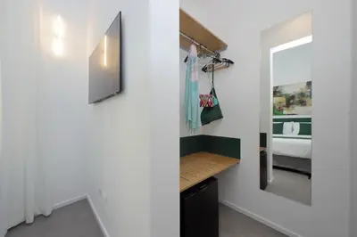 a bathroom with a vanity with a mirror and a bed at Youcomehere - Montebello in Rome