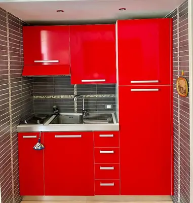 a red kitchen with a sink and red cabinets at Dolcevita’s House in Rome