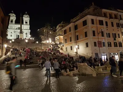 a crowd of people walking down a street at night at Relais Bocca di Leone in Rome