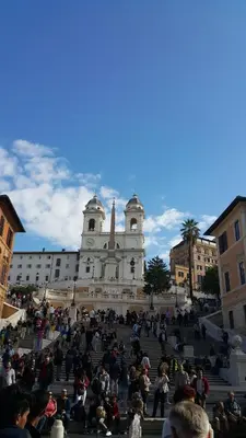 a group of people sitting on steps in front of a building at Relais Bocca di Leone in Rome