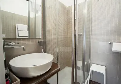 a bathroom with a white sink and a shower at Relais Bocca di Leone in Rome