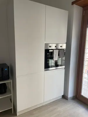 a white kitchen with a stove in a wall at Cozy home close to the city center in Rome